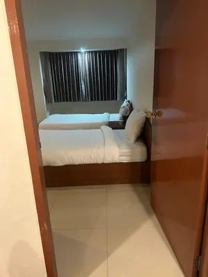 two beds in a small room with a window at Spacious 1,2 & 3 Bedroom Serviced Apartments OMNI - Nana BTS in Bangkok