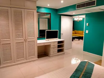 a bedroom with a desk with a computer on it at Spacious 1,2 & 3 Bedroom Serviced Apartments OMNI - Nana BTS in Bangkok
