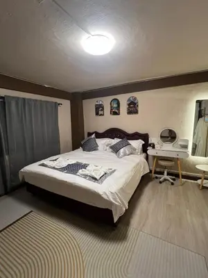 a bedroom with a bed and a desk with a computer at Moochi Relax L'Assommior in Bangkok