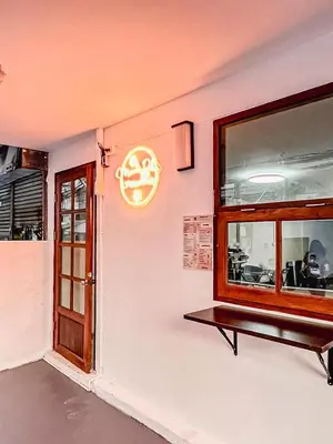 a restaurant with a window and a sign on the wall at Moochi Relax L'Assommior in Bangkok