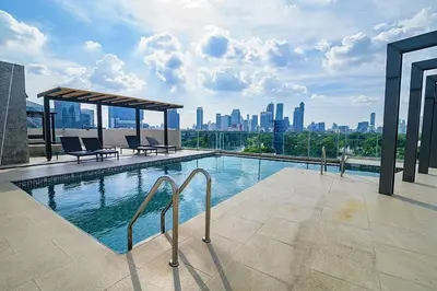 a swimming pool on top of a building with a city skyline at Cosy apartment - BTS Phrom phong in Bangkok
