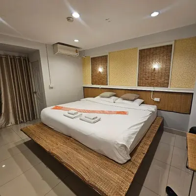 a bedroom with a large bed with a large white comforter at bang khun thian14 in Sathani Wat Sing