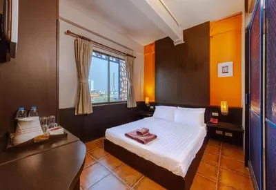 a hotel room with a bed and a window at Collection O Diamond House Khaosan in Bangkok