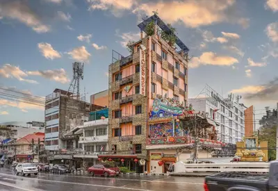 a tall building on a city street with cars at Collection O Diamond House Khaosan in Bangkok