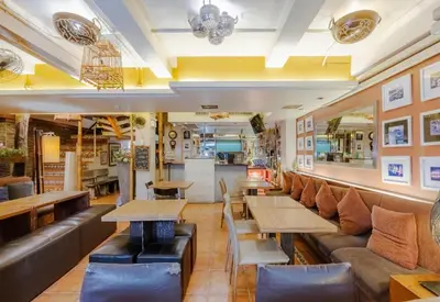a restaurant with tables and couches in a room at Collection O Diamond House Khaosan in Bangkok
