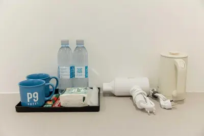 a counter with bottles of water and a coffee maker at P9 Ratchada Hotel in Bangkok