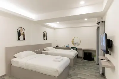 a hotel room with two beds and a tv at P9 Ratchada Hotel in Bangkok