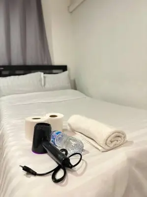 a white bed with a camera and towels on it at Chubbi 5 Room10 in Bang O