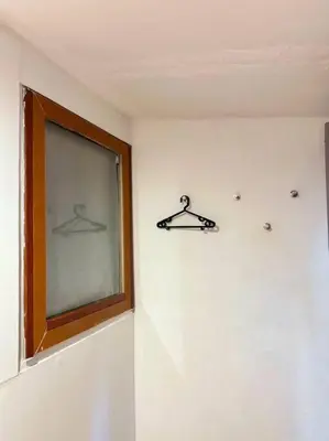 a room with two hangers on the wall and a window at Chubbi 5 Room10 in Bang O