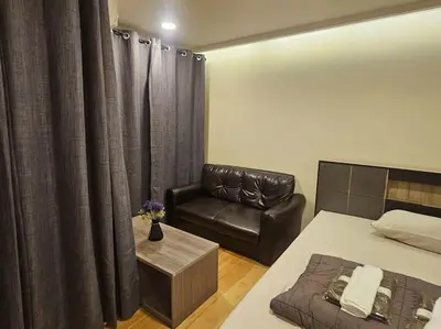 a bedroom with a bed and a couch and a chair at forest by Bangboon by Parisa in Sathani Wat Sing