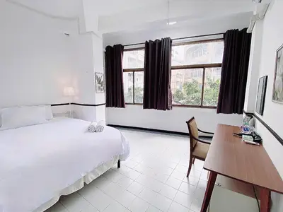 a bedroom with a bed and a desk and window at XX GO INN MRT Hua Lamphong China Town in Bangkok