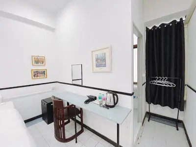 a white room with a table and a chair at XX GO INN MRT Hua Lamphong China Town in Bangkok