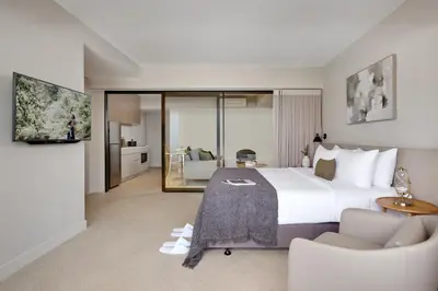 a bedroom with a large bed and a living room at Somerset Sukhumvit 71 Bangkok in Bangkok