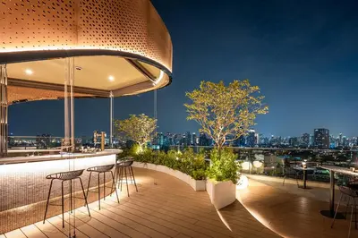 a rooftop bar with a view of the city at night at Somerset Sukhumvit 71 Bangkok in Bangkok