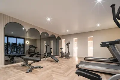a gym with treadmills and ellipticals in a room at Somerset Sukhumvit 71 Bangkok in Bangkok