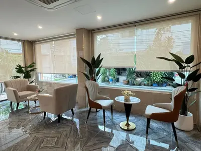 a living room with chairs and a table and a window at Icon Dome Bangkok in Bangkok