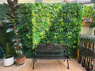 a bench in front of a green wall with plants at Icon Dome Bangkok in Bangkok