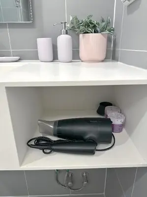 a hair dryer sitting on a shelf in a bathroom at Luxury loft with Stunning 35th Floor Views in Bangkok