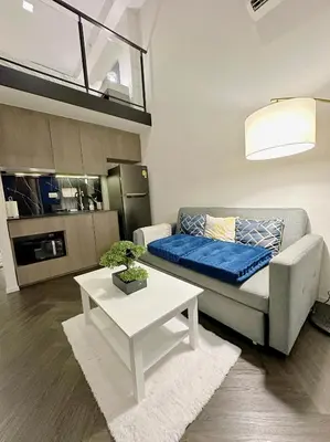 a living room with a couch and a table at Luxury loft with Stunning 35th Floor Views in Bangkok