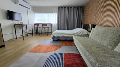 a hotel room with a couch and a bed at อิมแพ็ค เมืองทองธานี ห้องพักรายวัน Popular Condo T8 in Nonthaburi