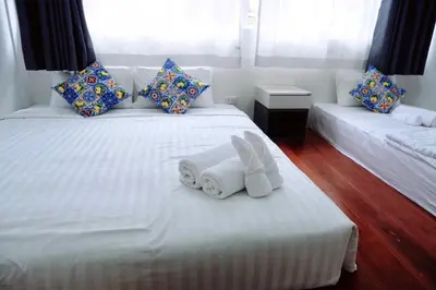 a hotel room with two beds with towels on them at Oskar's House in Bangkok
