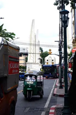 a small green car driving down a city street at Oskar's House in Bangkok