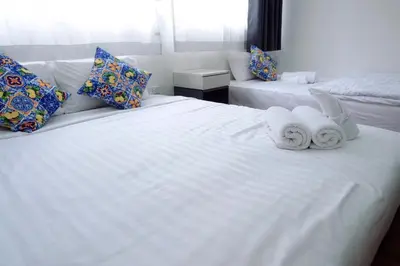 a bedroom with two towels on a white bed at Oskar's House in Bangkok