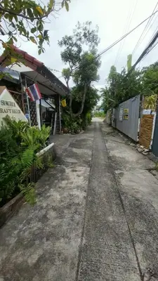 an empty street with trees and a building at ที่พักนักเดินทาง ภู่ระหงษ์ in Bangkok