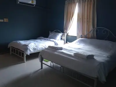 two twin beds in a room with a window at ที่พักนักเดินทาง ภู่ระหงษ์ in Bangkok