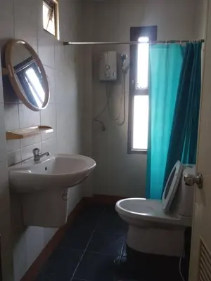 a bathroom with a sink and a toilet and a mirror at ที่พักนักเดินทาง ภู่ระหงษ์ in Bangkok