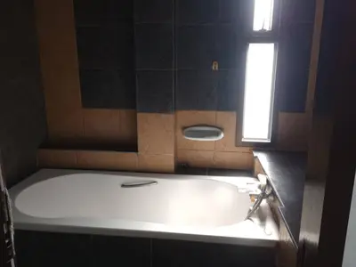 a bath tub in a bathroom with a window at ที่พักนักเดินทาง ภู่ระหงษ์ in Bangkok