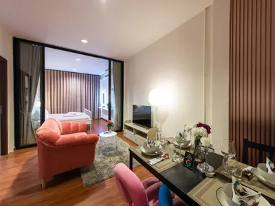 a living room with a red chair and a table at The City Yaowarat in Samphanthawong