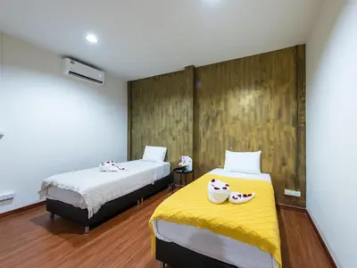 a bedroom with two beds and a yellow blanket at The City Yaowarat in Samphanthawong