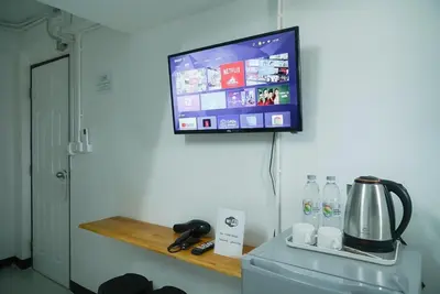 a flat screen tv hanging on a wall above a refrigerator at GO INN Bangkok Rama3 โกอินน์ พระราม3 in Bangkok