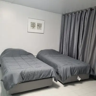 a bedroom with two twin beds and a curtain at Popular Muang Thong Thani Condo, Building T9, Floor 8, Room 13 in Pak Kret