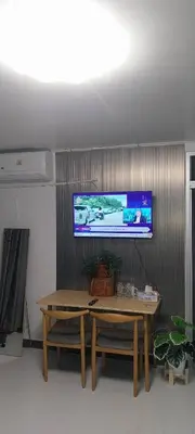 a living room with a table and a tv on a wall at Popular Muang Thong Thani Condo, Building T9, Floor 8, Room 13 in Pak Kret