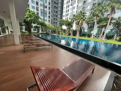 a swimming pool in the middle of a building with benches at Aspire Rattanatibet 2 at MRT Purple Line in Nonthaburi