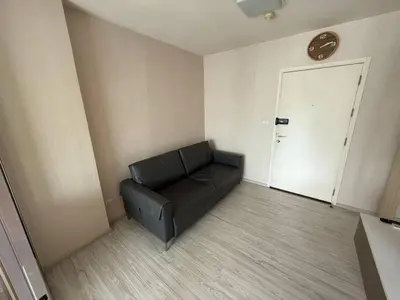 a black couch in a room with a door at Aspire Rattanatibet 2 at MRT Purple Line in Nonthaburi