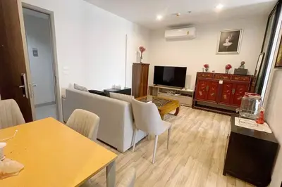 a living room with a table and chairs and a television at Niche Mono 2 Bedroom next to BTS Bearing in Samut Prakan