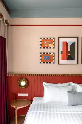 a bedroom with a red and white bed and a table at Blu Dock Restel Bangkok in Bangkok