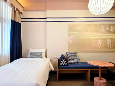 a bedroom with a bed and a blue bench at Blu Dock Restel Bangkok in Bangkok