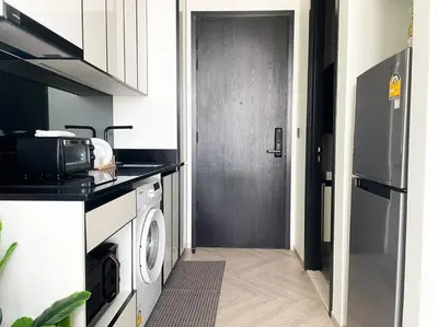 a kitchen with a washing machine and a door at Luxurious River View chao phraya river in Bangkok