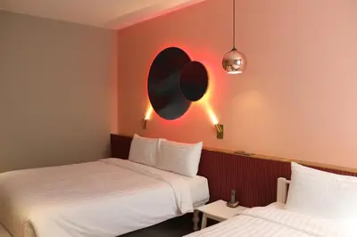 two beds in a room with pink walls at Riva Vibe Hotel Bangkok by PCL in Bangkok