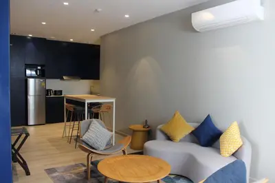 a living room with a couch and a table at Riva Vibe Hotel Bangkok by PCL in Bangkok