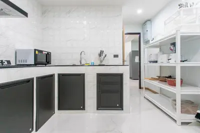 a kitchen with black cabinets and a white counter top at Psalms 23 Residence in Bangkok