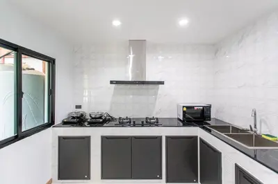 a white kitchen with a stove and a sink at Psalms 23 Residence in Bangkok