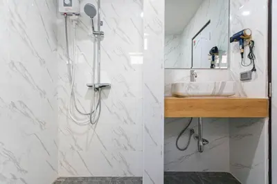 a white bathroom with a shower and a sink at Psalms 23 Residence in Bangkok