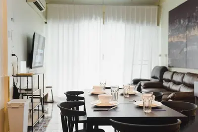 a dining room with a table with chairs and a couch at 3BR Entire Home - Close to Train, Boat, IconSiam, Asiatique in Bangkok