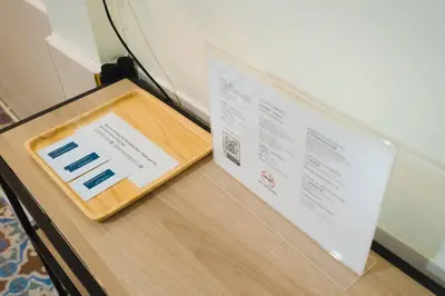 a box on top of a wooden table with a menu at 3BR Entire Home - Close to Train, Boat, IconSiam, Asiatique in Bangkok