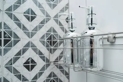 a shelf with two perfume bottles on a tile wall at 3BR Entire Home - Close to Train, Boat, IconSiam, Asiatique in Bangkok